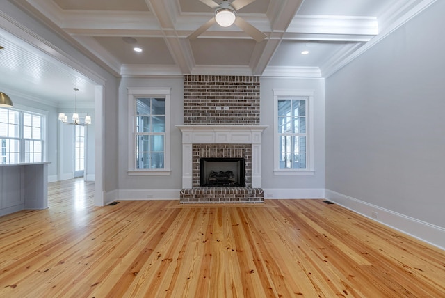 unfurnished living room featuring a fireplace, ornamental molding, coffered ceiling, light hardwood / wood-style flooring, and beamed ceiling