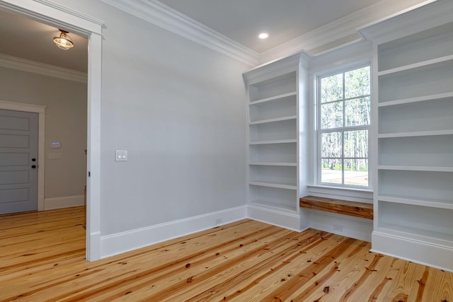 spare room with light wood-type flooring and crown molding