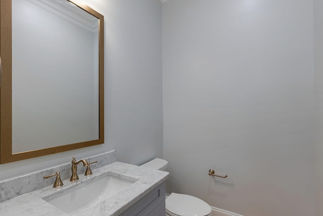 bathroom with crown molding, vanity, and toilet