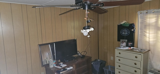 room details featuring ceiling fan and wooden walls