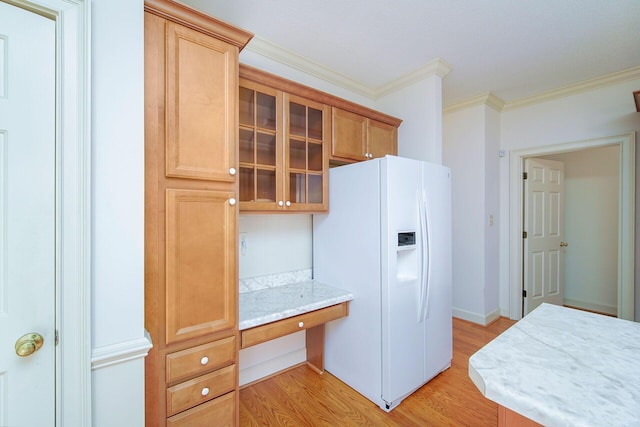 kitchen with crown molding, white fridge with ice dispenser, built in desk, and light hardwood / wood-style floors