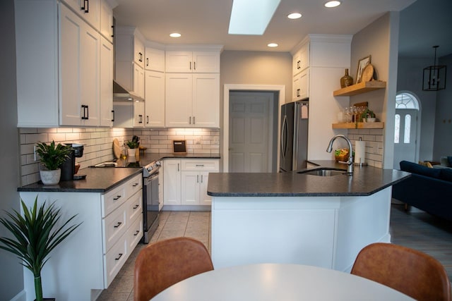 216 Sumter Ln, Mccormick, SC 29835 - kitchen featuring appliances with stainless steel finishes, dark countertops, a skylight, open shelves, and tasteful backsplash