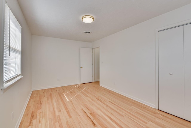 unfurnished bedroom with a textured ceiling and light hardwood / wood-style flooring