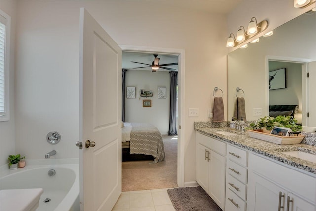 full bath featuring a bath, double vanity, a sink, and ensuite bath