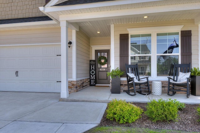 view of exterior entry featuring covered porch, a garage, and stone siding