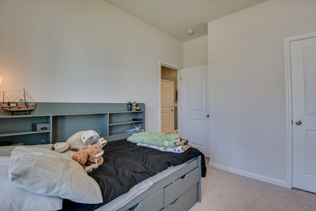 bedroom with baseboards and light colored carpet