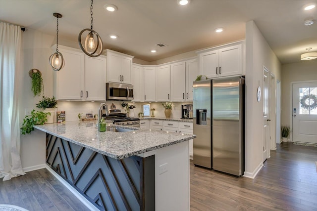 kitchen featuring appliances with stainless steel finishes, white cabinets, a sink, a peninsula, and dark wood-type flooring
