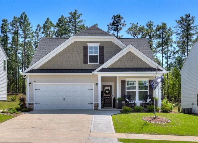 craftsman house with covered porch, a shingled roof, a front lawn, and concrete driveway