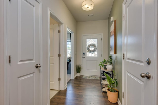 entryway with dark wood-style floors, visible vents, and baseboards