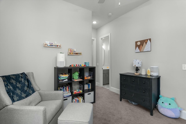 living area with light carpet and ceiling fan