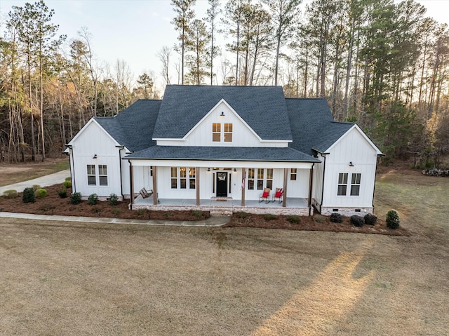 modern inspired farmhouse with a front yard and a porch