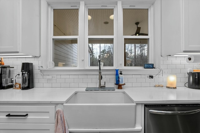 kitchen with tasteful backsplash, white cabinetry, sink, and stainless steel dishwasher