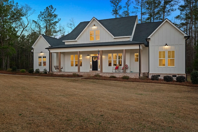 modern inspired farmhouse with a porch and a lawn