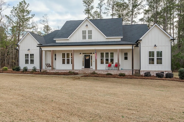 modern farmhouse style home featuring covered porch and a front yard