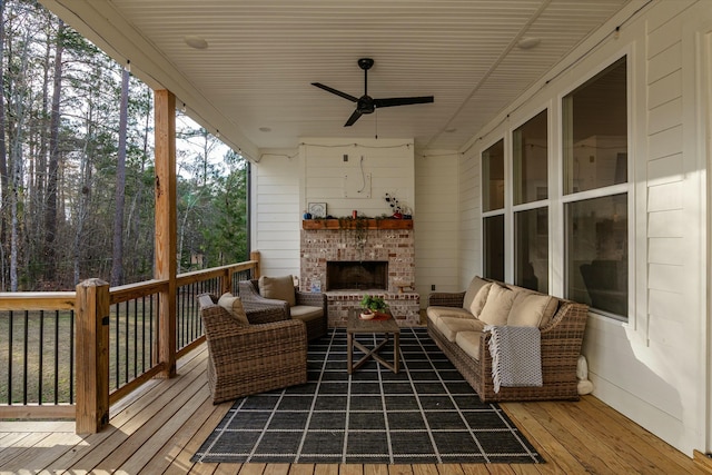 deck featuring ceiling fan and an outdoor living space with a fireplace