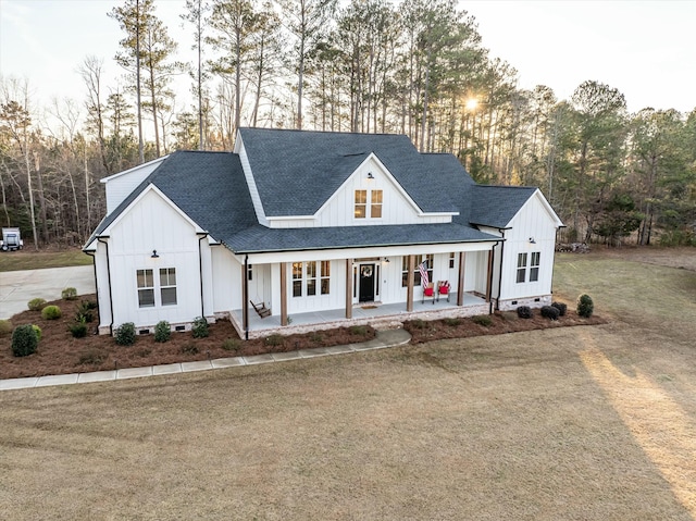 modern farmhouse style home featuring a yard and covered porch