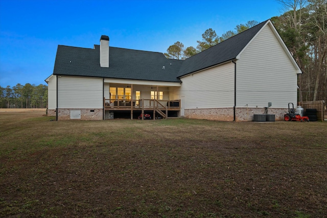 rear view of property featuring cooling unit, a yard, and a deck