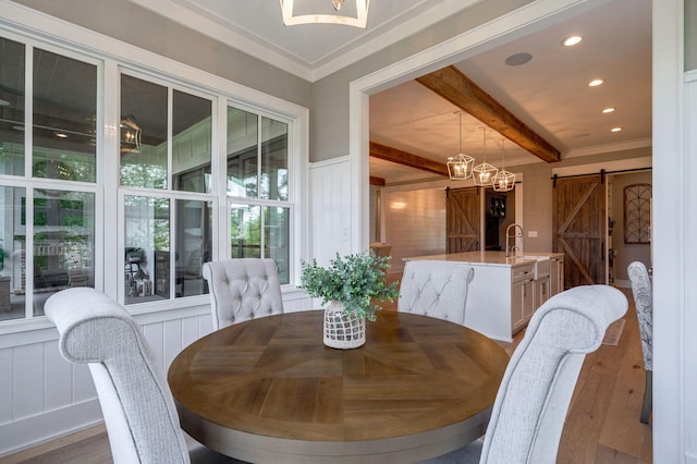 188 Lagoon Dr, Clarks Hill, SC 29821 - dining room featuring a barn door, wood finished floors, beam ceiling, a chandelier, and a decorative wall