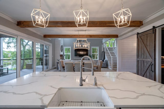 188 Lagoon Dr, Clarks Hill, SC 29821 - kitchen with a chandelier, beamed ceiling, open floor plan, a barn door, and light stone counters