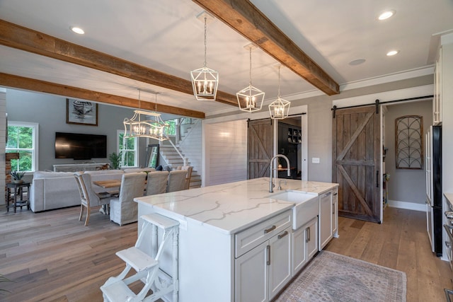 188 Lagoon Dr, Clarks Hill, SC 29821 - kitchen with a barn door, beam ceiling, white cabinets, light wood finished floors, and white dishwasher