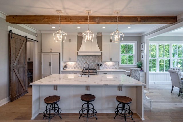 188 Lagoon Dr, Clarks Hill, SC 29821 - kitchen featuring premium range hood, a barn door, white cabinetry, beam ceiling, and decorative backsplash