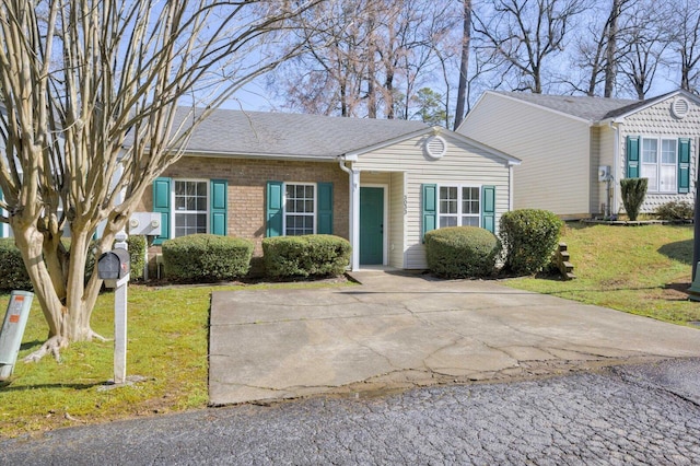 ranch-style home featuring a front yard, brick siding, and a shingled roof