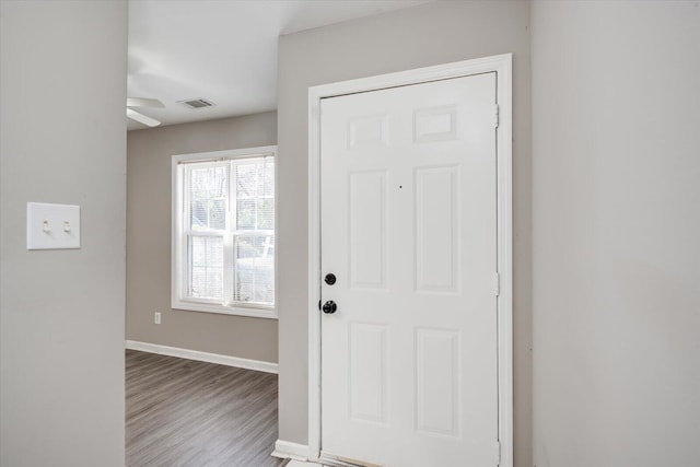 foyer featuring visible vents, baseboards, and wood finished floors