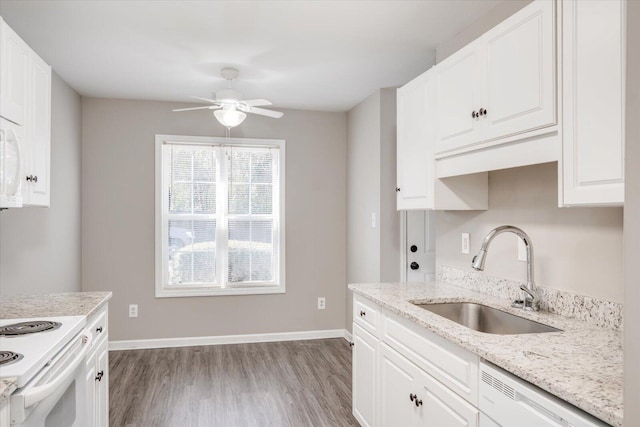 kitchen with baseboards, dishwasher, wood finished floors, white cabinets, and a sink