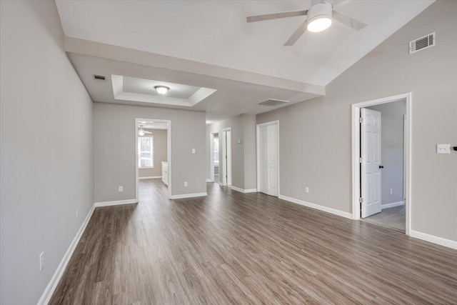 unfurnished room featuring visible vents, baseboards, and wood finished floors