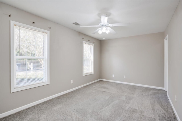 unfurnished room with carpet flooring, visible vents, baseboards, and ceiling fan