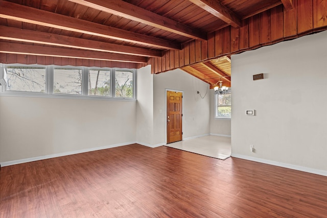 spare room with wood finished floors, wooden ceiling, baseboards, and an inviting chandelier