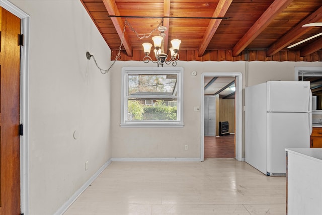 unfurnished dining area featuring wood ceiling, beam ceiling, baseboards, and an inviting chandelier