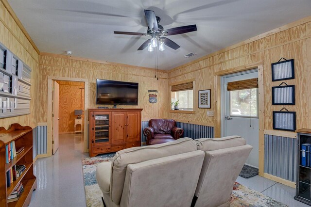 living room with wood walls and ceiling fan