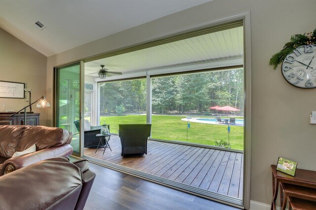 doorway featuring hardwood / wood-style floors, ceiling fan, and vaulted ceiling