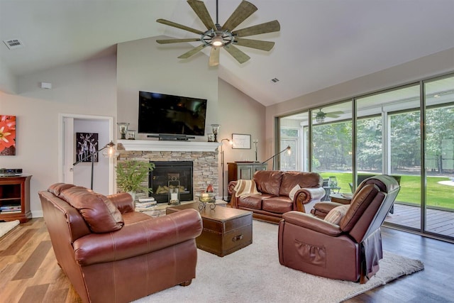 1370 Deerwood Cir, Stapleton, GA 30823 - living area featuring ceiling fan, high vaulted ceiling, wood finished floors, and a stone fireplace