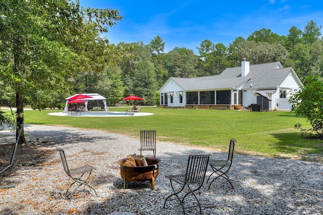 1370 Deerwood Cir, Stapleton, GA 30823 - rear view of house featuring an outdoor fire pit, a gazebo, a sunroom, a lawn, and a chimney