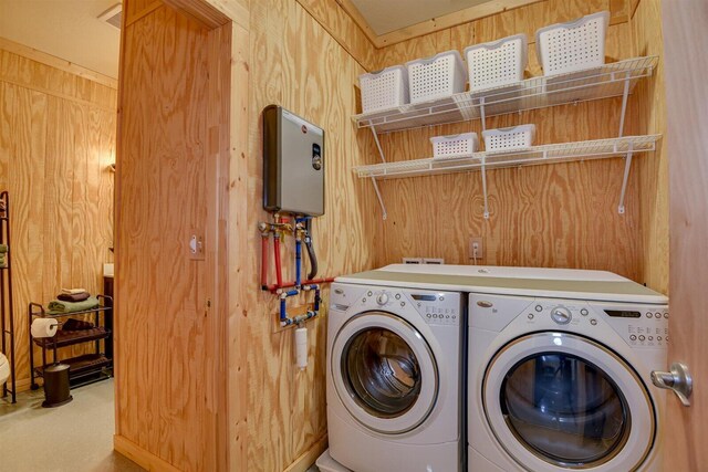 washroom with independent washer and dryer and wood walls