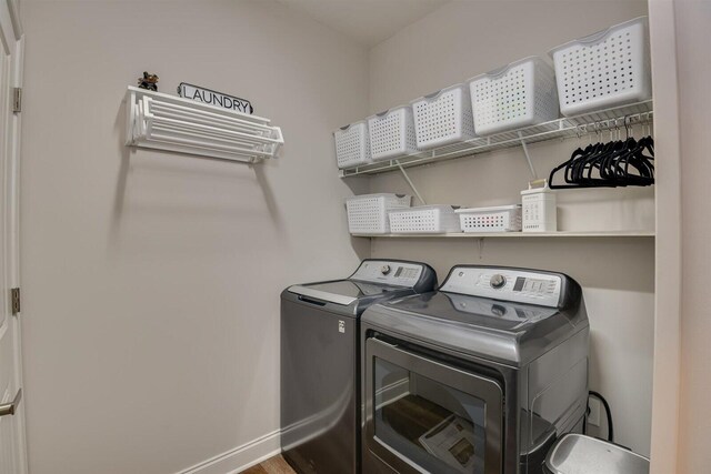 clothes washing area featuring hardwood / wood-style floors and washing machine and dryer