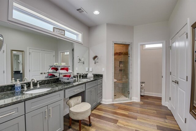 bathroom with wood-type flooring, vanity, and an enclosed shower