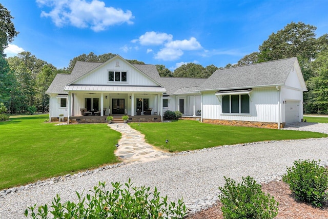 modern inspired farmhouse featuring covered porch, a garage, and a front yard