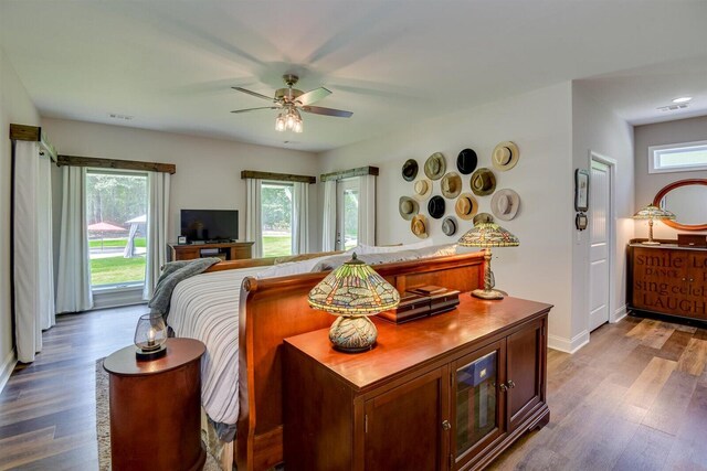 bedroom featuring multiple windows, ceiling fan, and wood-type flooring