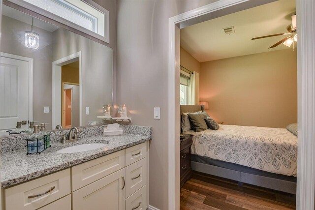 bedroom featuring ceiling fan with notable chandelier, multiple windows, dark wood-type flooring, and sink