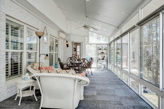 sunroom with ceiling fan, a wall mounted AC, and vaulted ceiling