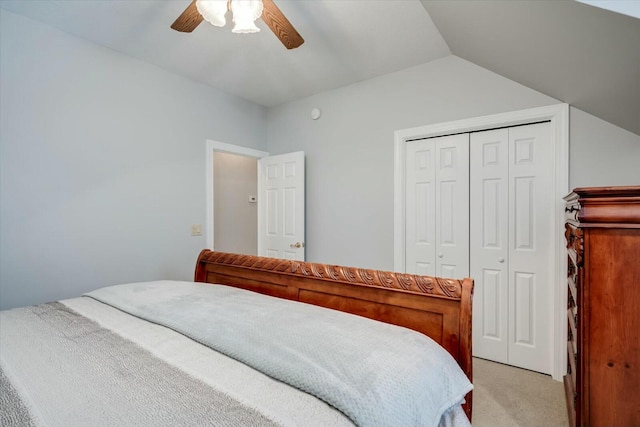 bedroom featuring a closet, light carpet, ceiling fan, and vaulted ceiling