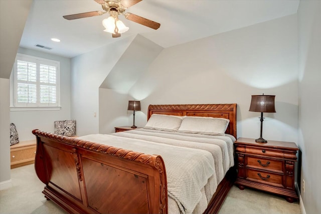 bedroom with visible vents, light colored carpet, lofted ceiling, and ceiling fan