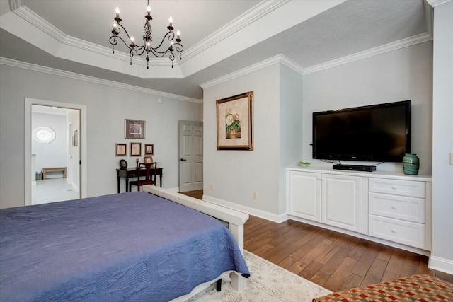 bedroom featuring a raised ceiling, a notable chandelier, dark wood-style flooring, and crown molding