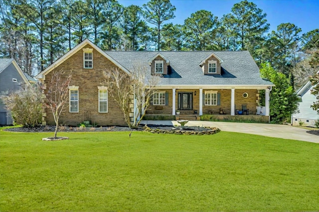 cape cod house with a front lawn, concrete driveway, and covered porch