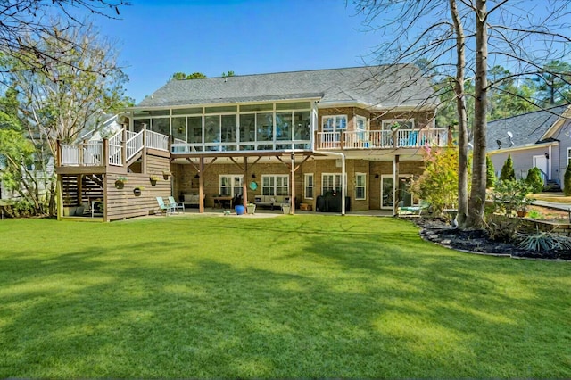 rear view of property with stairway, a lawn, a patio, and a sunroom