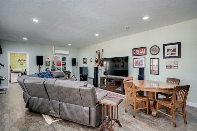 living room with baseboards, a wall mounted air conditioner, recessed lighting, wood finished floors, and a textured ceiling