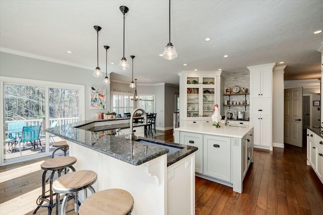 kitchen featuring a sink, an island with sink, and ornamental molding